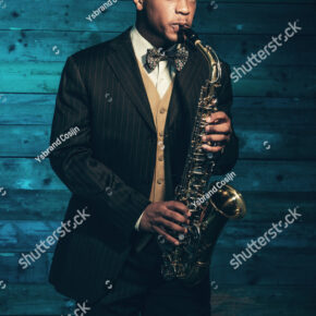 stock-photo-vintage-african-american-jazz-musician-with-saxophone-in-front-of-old-wooden-wall-wearing-suit-and-230214829.jpg 